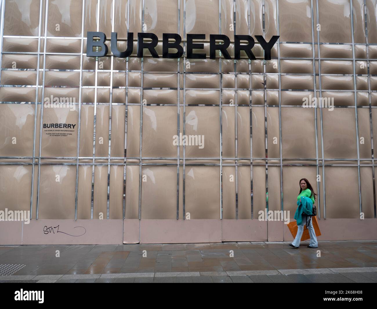 Mayfair, Londra, Regno Unito, accaparramento temporaneo di fronte al negozio Burberry durante la ristrutturazione, con gli acquirenti che passano davanti Foto Stock