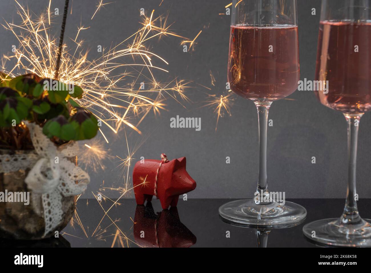 Auguri di Capodanno con trifoglio fortunato, vino frizzante, lucente e maiali fortunati Foto Stock