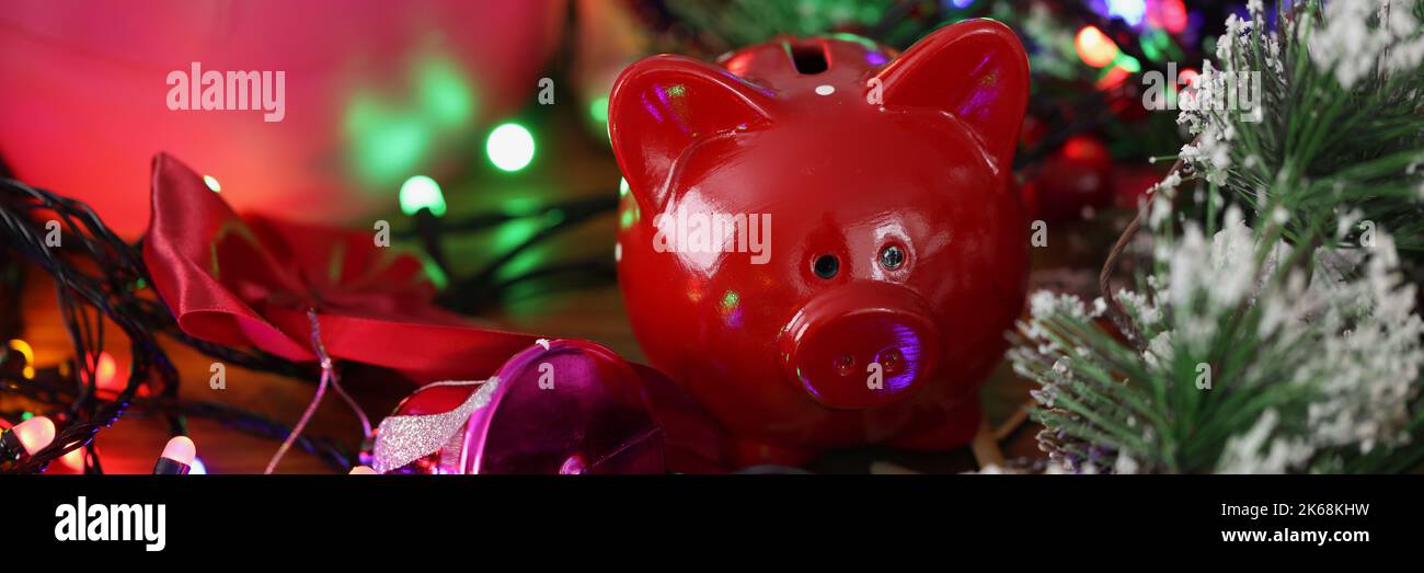 Red Piggy banca in piedi tra brillante lucido anno nuovo garland primo piano Foto Stock