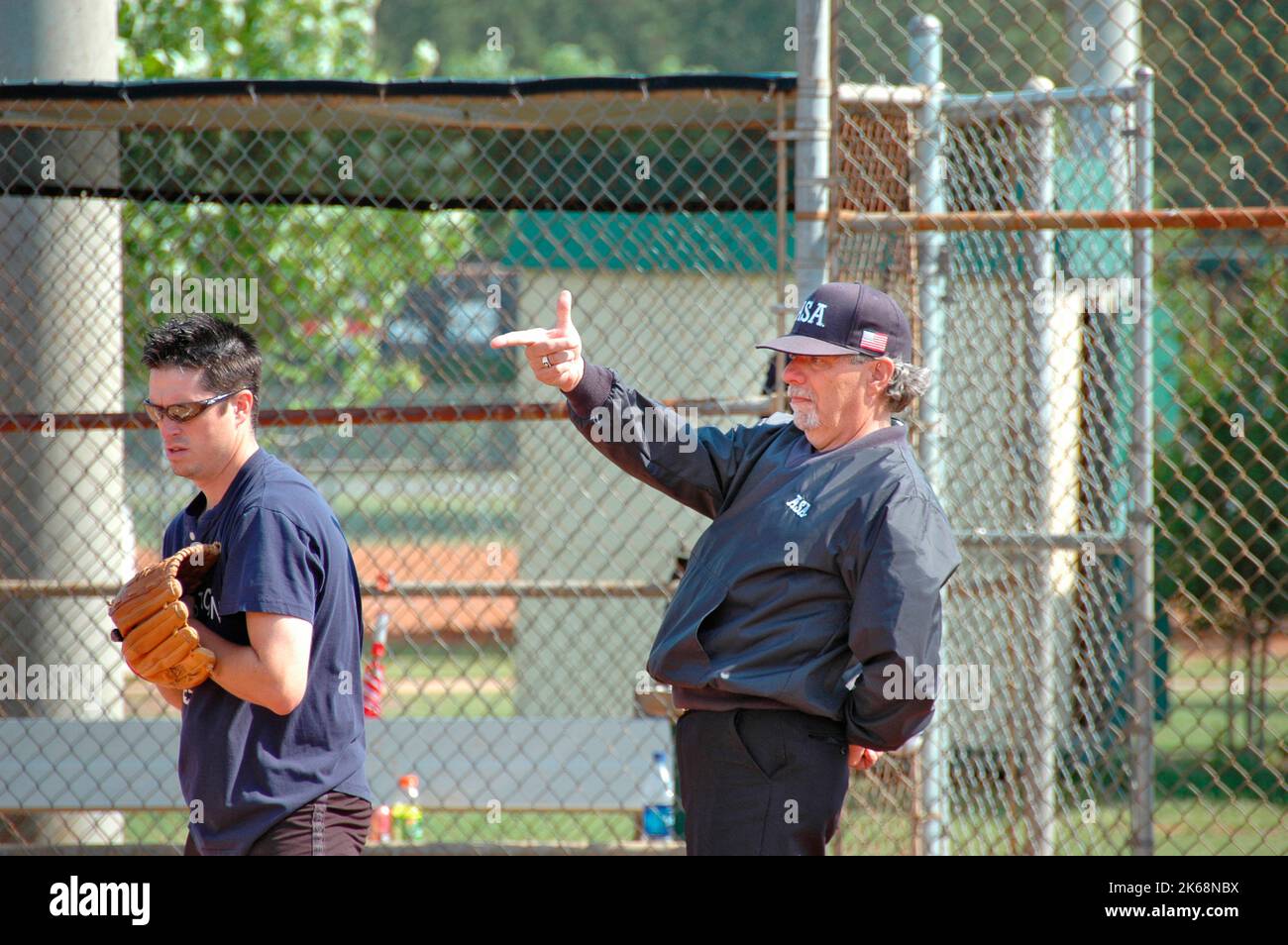 Softball umpires per ASA negli Stati Uniti durante i giochi che fanno le chiamate e nel controllo pre-partita pipistrelli e lineup e regole e tali chiedendo che il lanciatore a pit Foto Stock