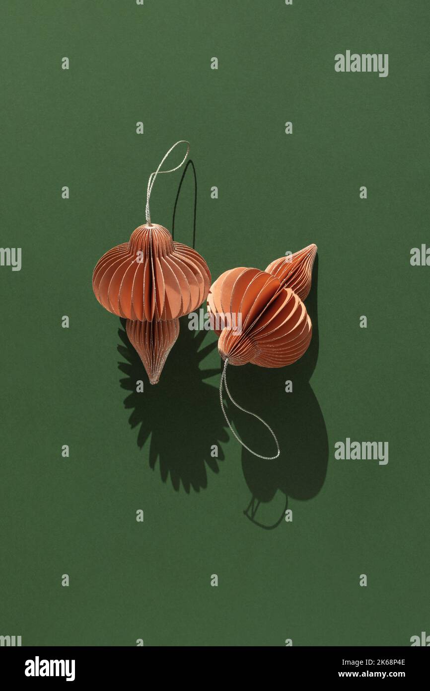 Due decorazioni di carta di Natale su sfondo verde con spazio di copia. Giacitura piatta. Foto Stock