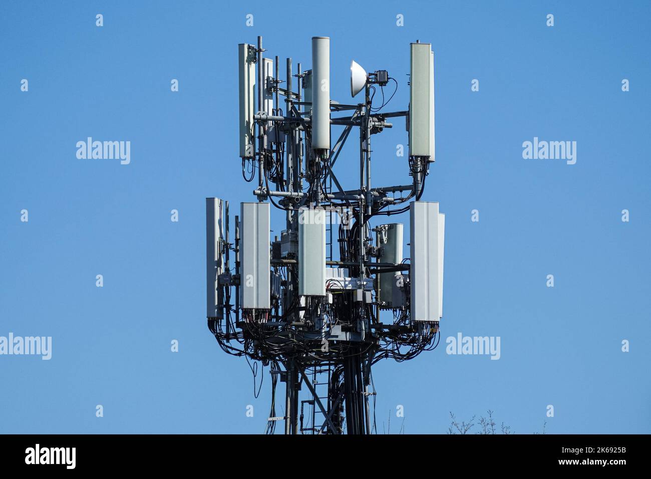 Cellulare, cellulare torre di telecomunicazione con antenne su cielo blu Foto Stock