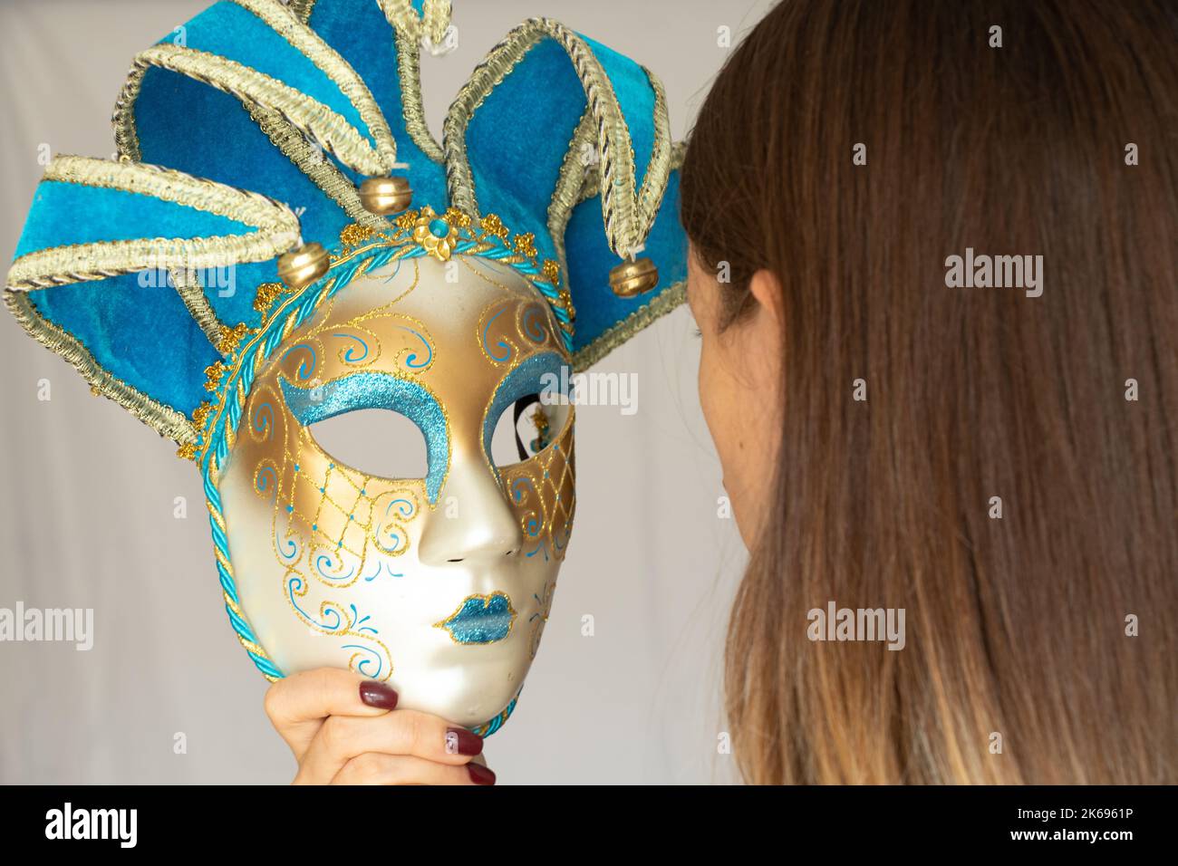 Il volto di una ragazza in una maschera di carnevale veneziana su uno sfondo isolato, mascherata e attore mascherato, teatro Foto Stock