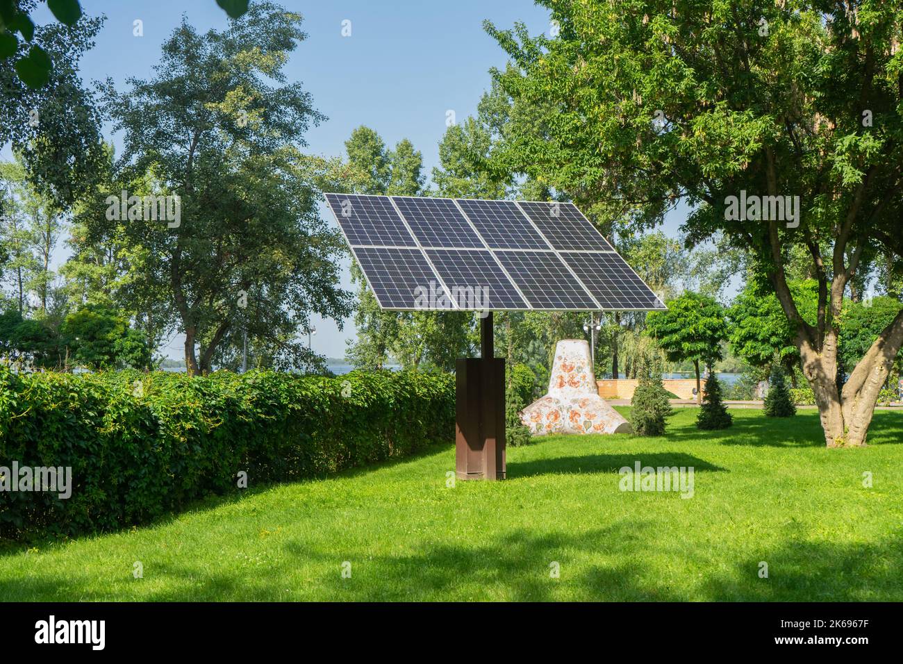 Pannelli solari nel retro del parco pubblico. Moduli fotovoltaici per energie rinnovabili, sistema di generatori elettrici dal sole. Tecnologie pulite, gree Foto Stock