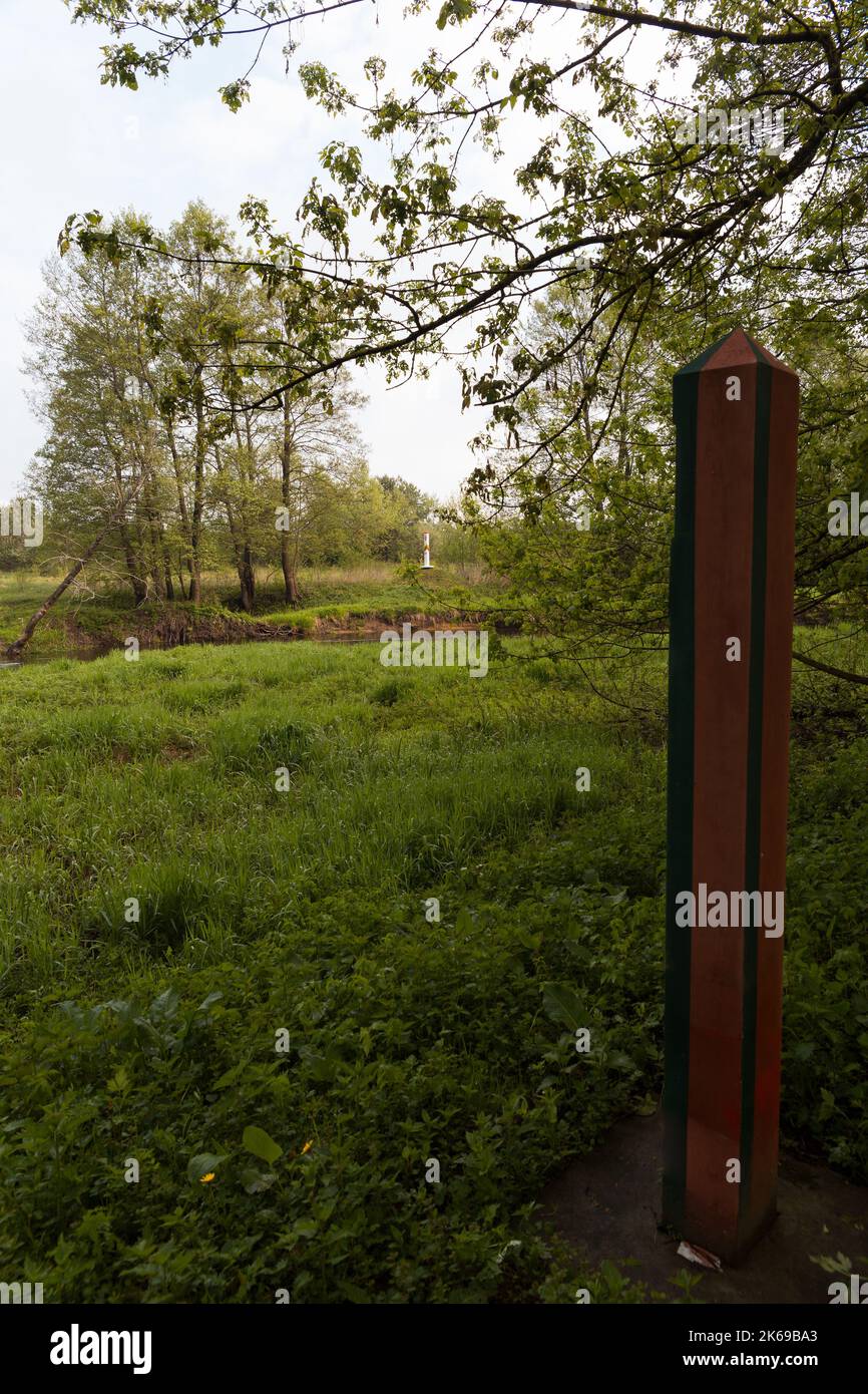 Pali di frontiera sulla linea di confine tra Lituania e Bielorussia sul fiume Black Gancha. Foto Stock