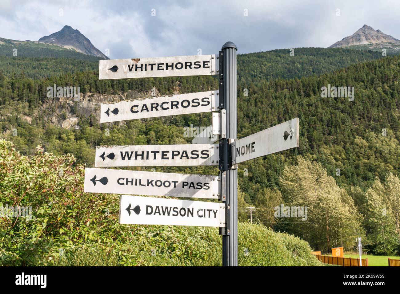 Indicazione direzionale che indica le città vicino Skagway, Alaska Foto Stock