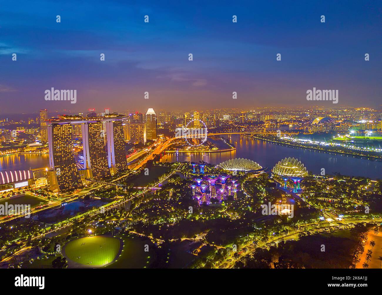 Vista aerea dei grattacieli di Singapore con skyline della città durante il giorno estivo nuvoloso. Leggermente morbido e rumoroso grazie all'elevato livello iso e alla lunga esposizione. Foto Stock
