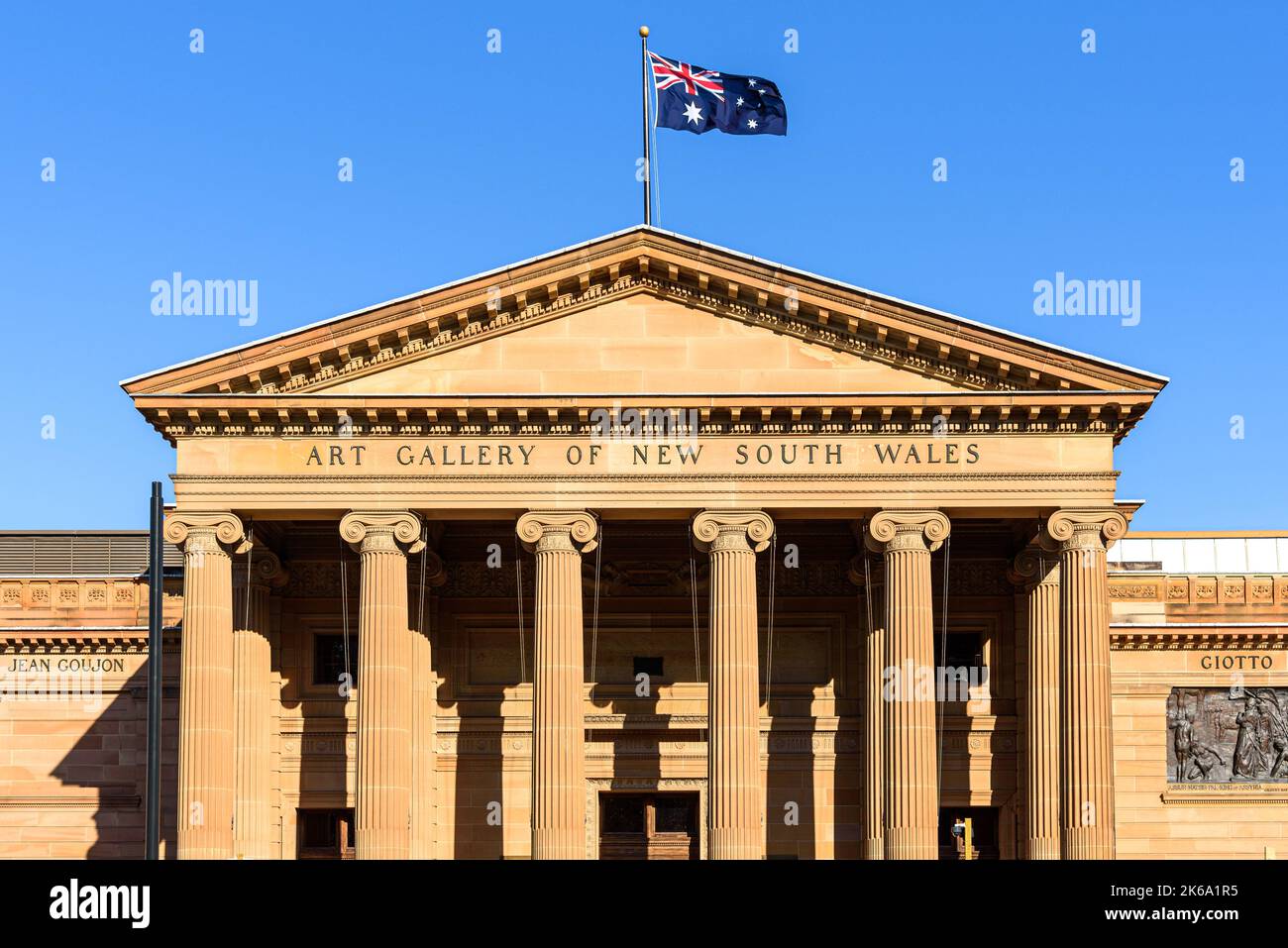 La facciata della Galleria d'Arte del nuovo Galles del Sud con colonne ioniche e una bandiera australiana in cima ad essa Foto Stock