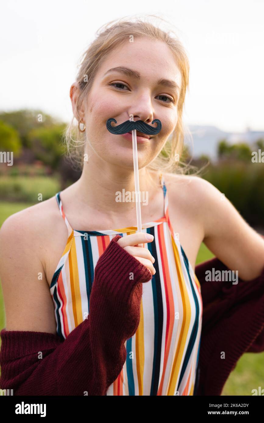 Ritratto di felice donna caucasica con falsi baffi Foto Stock