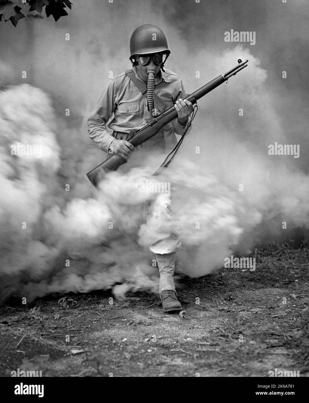 Soldato con fucile durante l'addestramento della maschera a gas a Fort Belvoir, Virginia, durante la seconda guerra mondiale, 1942. Foto Stock