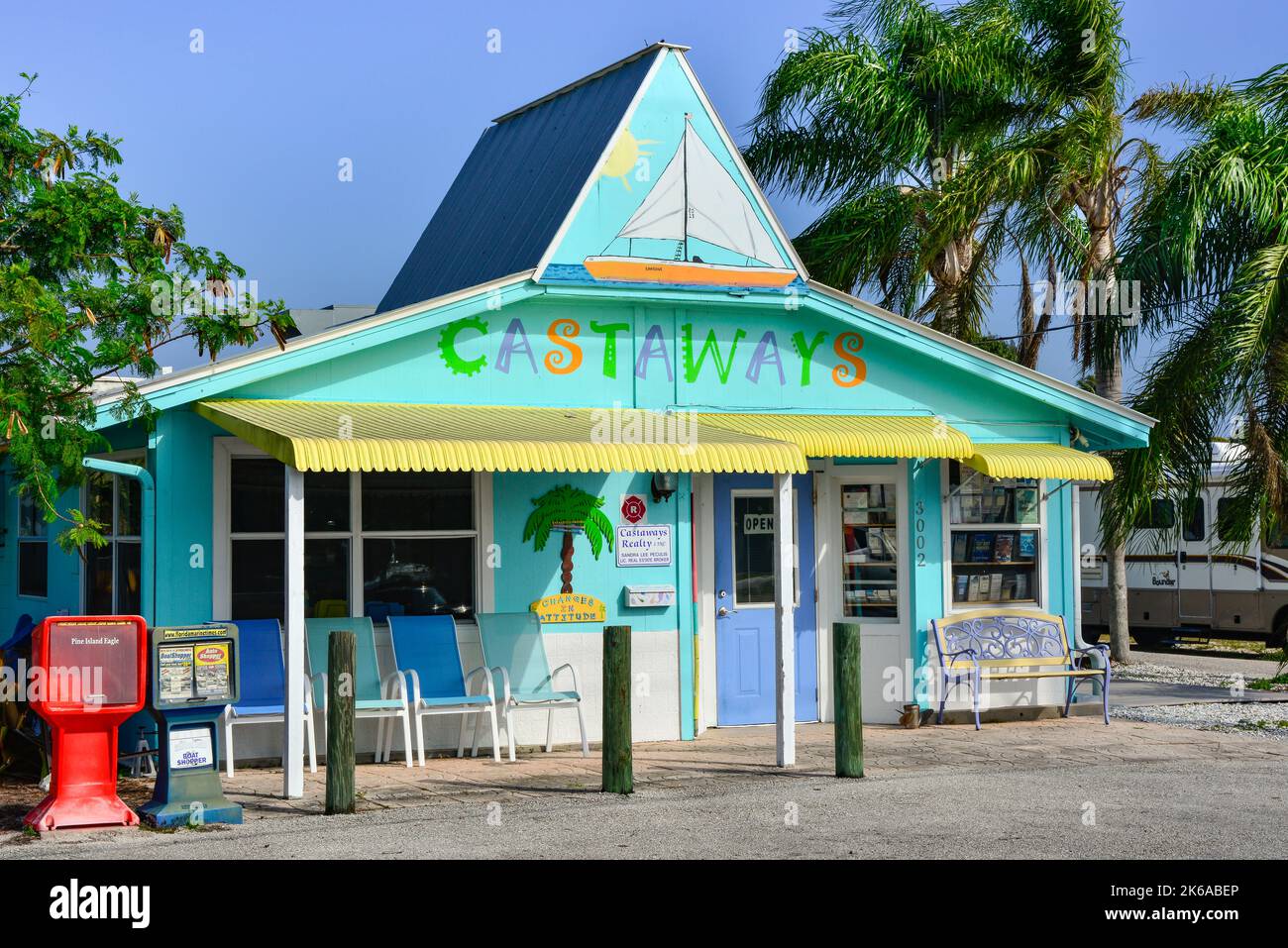 Un affascinante edificio in colori pastello ospita il Castaways Realty business con palme e l'isola di Vibe in St James City a Pine Island, Florida Foto Stock