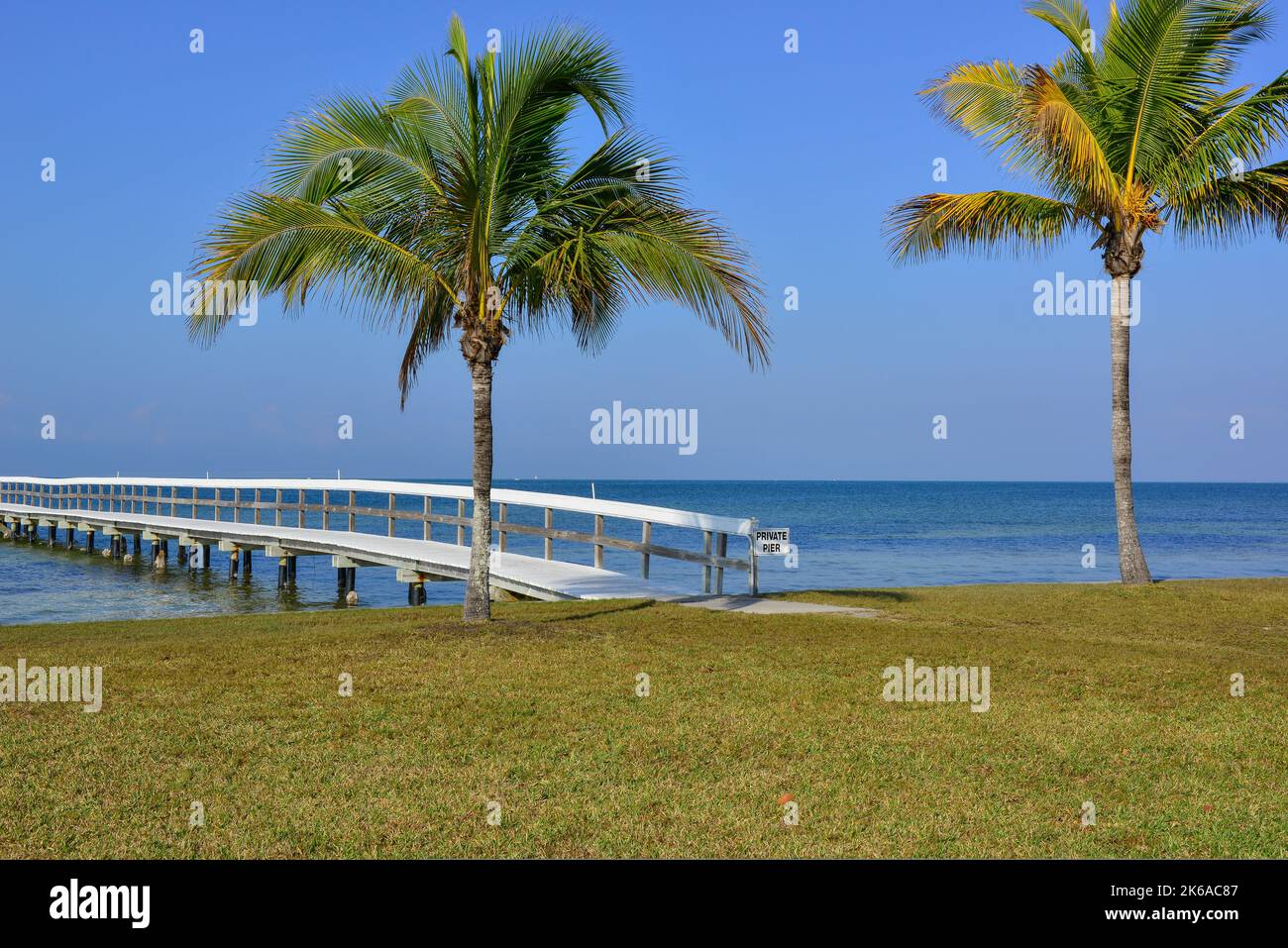 Una serena vista panoramica sul Porto di Charlotte di un molo di legno e palme a Bokeelia, Florida, su Pine Island, la quintessenza della Vecchia Florida Foto Stock