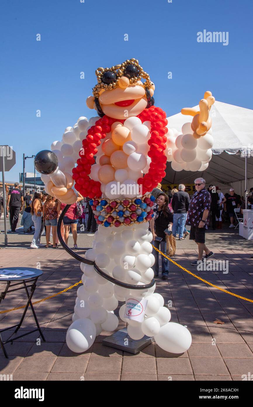 Una scultura in mongolfiera di Elvis Presley, cantante di rock and roll, completa di occhiali da sole e microfono, accoglie i visitatori di un festival di Elvis Foto Stock