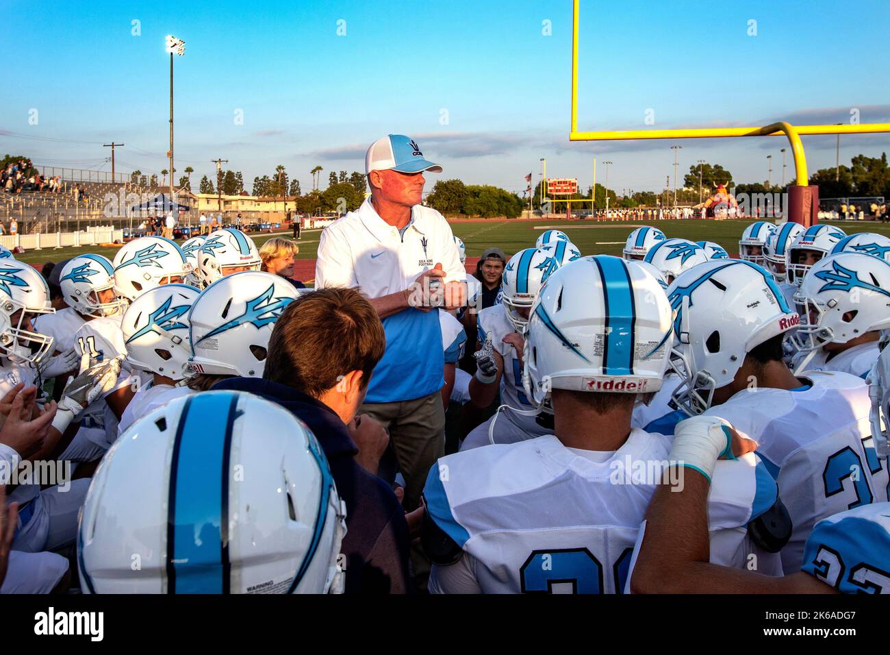 Un allenatore di calcio della scuola superiore offre un peptalk ai suoi giocatori prima di una partita a Downey, California. Foto Stock