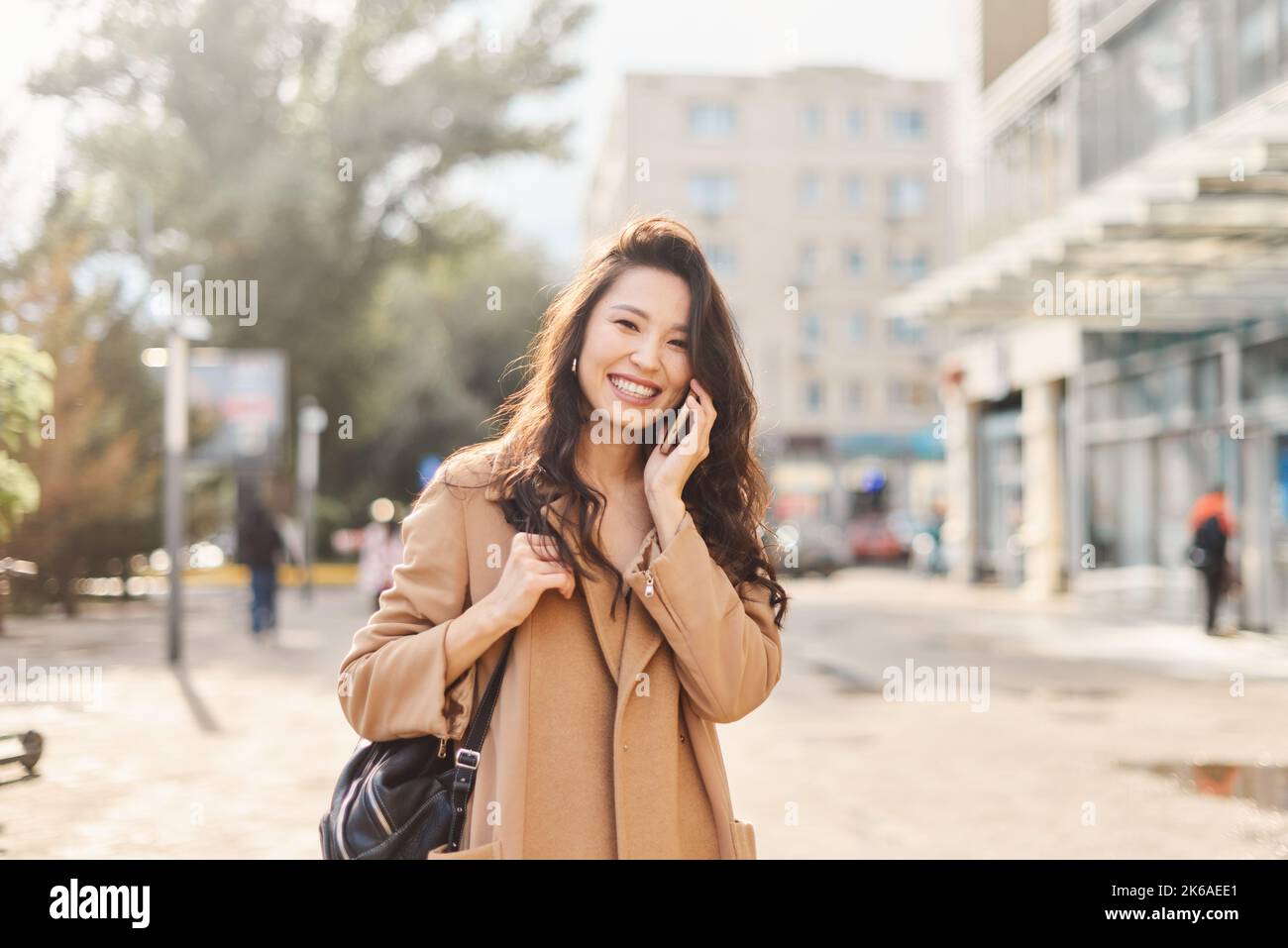 Lifestyle ritratto felice asiatico kazako donna che parla sul telefono cellulare e ridendo Foto Stock