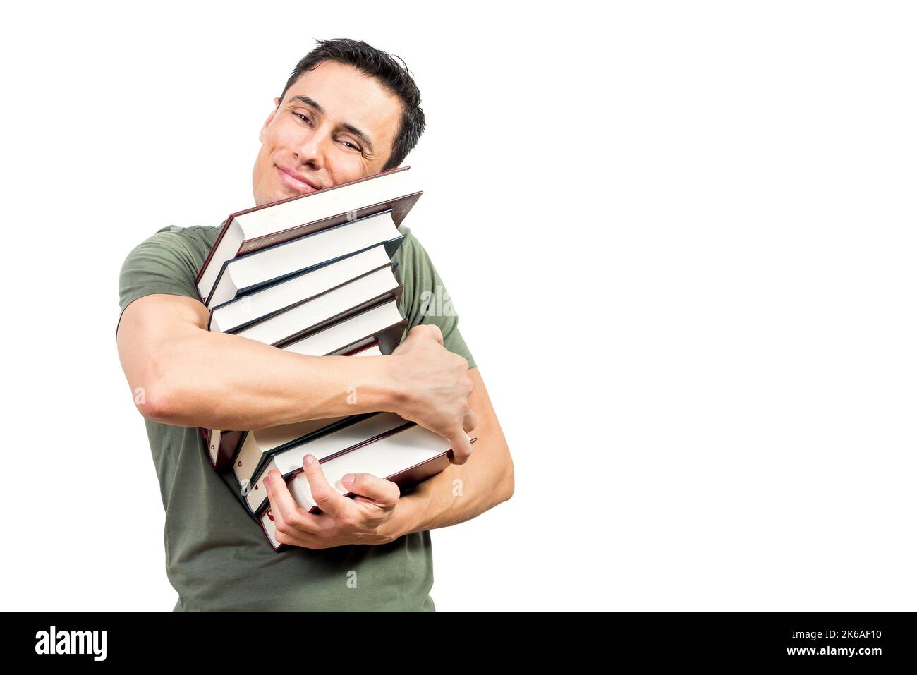 Uomo soddisfatto che abbraccia libri e guarda la macchina fotografica Foto Stock