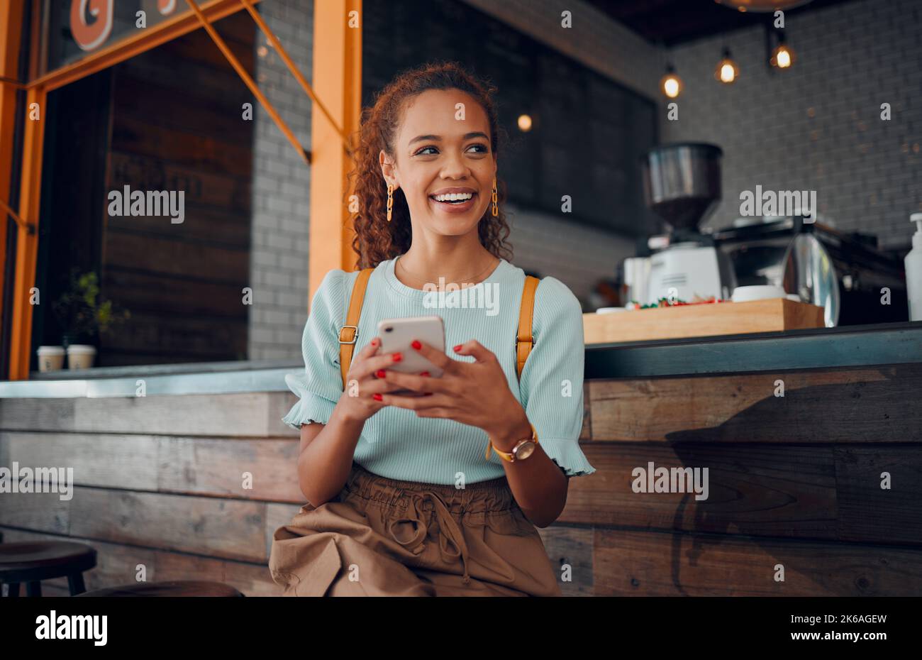 Telefono, social media e bar con una cliente donna che pensa a un'idea mentre si siede al bancone in un bar. Mobile, Internet e comunicazione Foto Stock