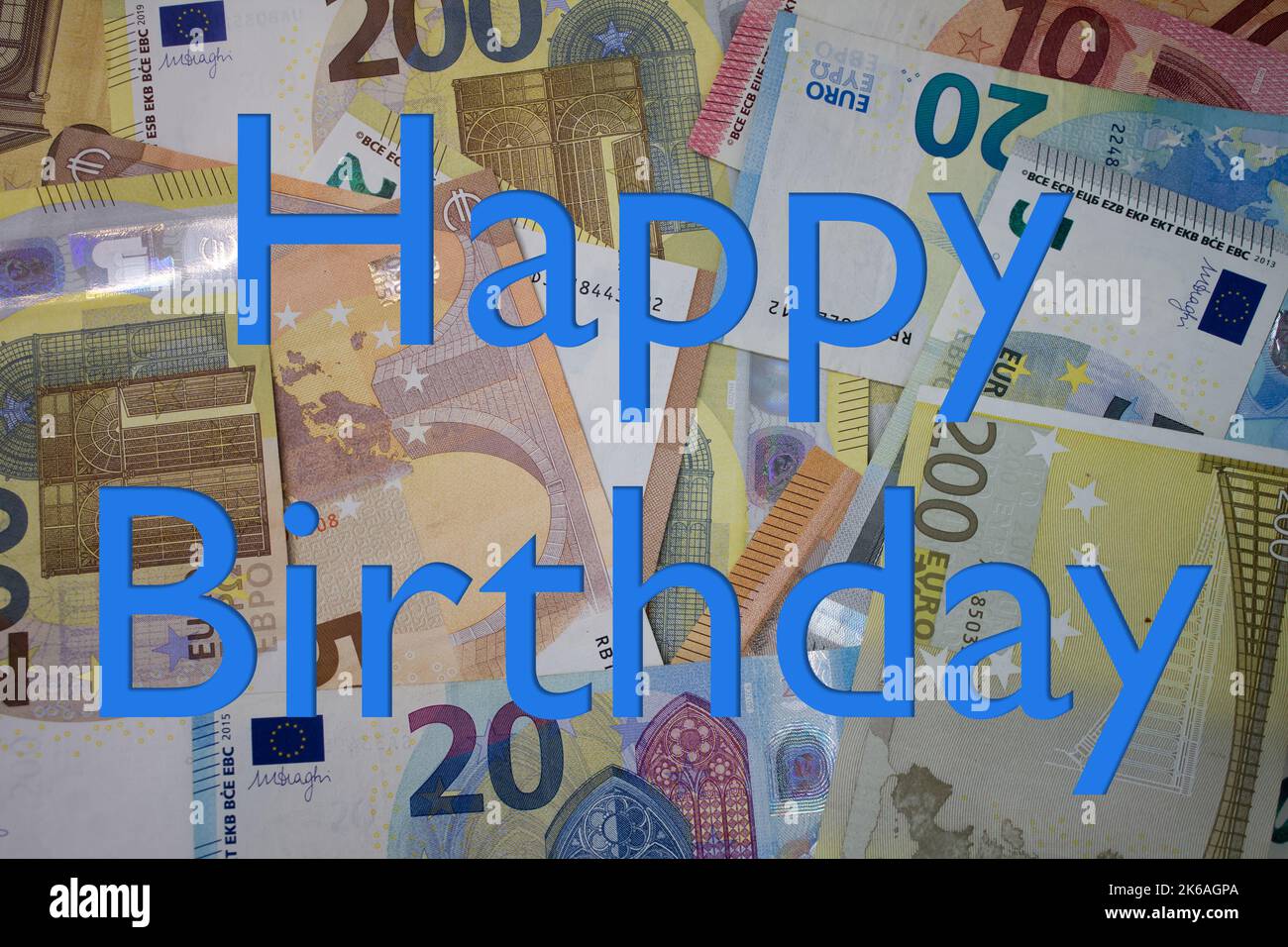 Buon compleanno parola con soldi. Sfondo di valuta cartacea con banconote diverse. Foto Stock