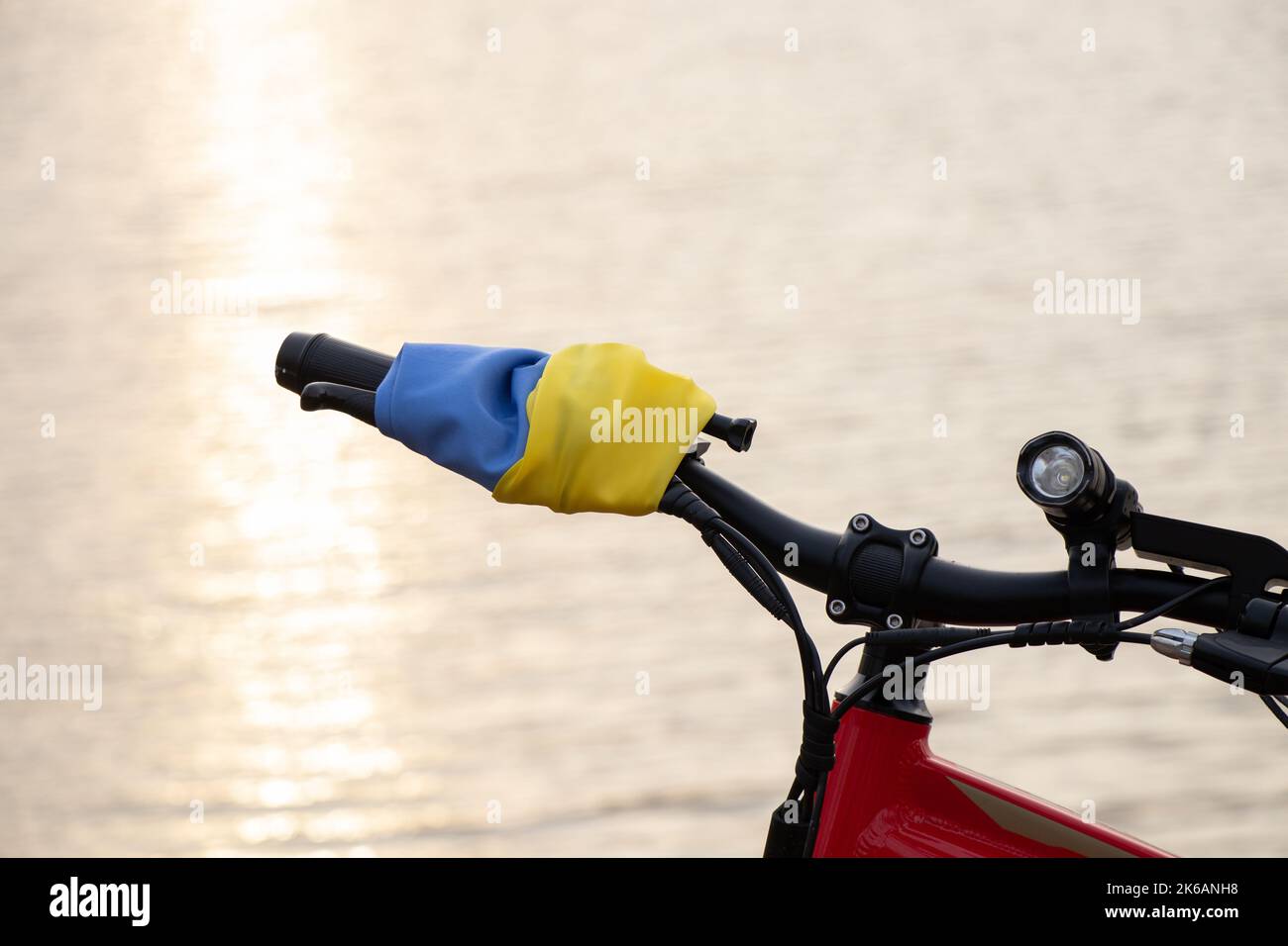Bandiera giallo-blu dell'Ucraina su una bicicletta in una città in Ucraina, un'azione di protesta, fermare la guerra in Ucraina, un patriota del suo paese 2022 Foto Stock