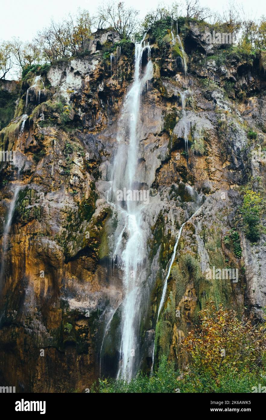 Un colpo verticale di Grande cascata che scorre giù ripida collina rocciosa in Plitvica Selo, Croazia Foto Stock