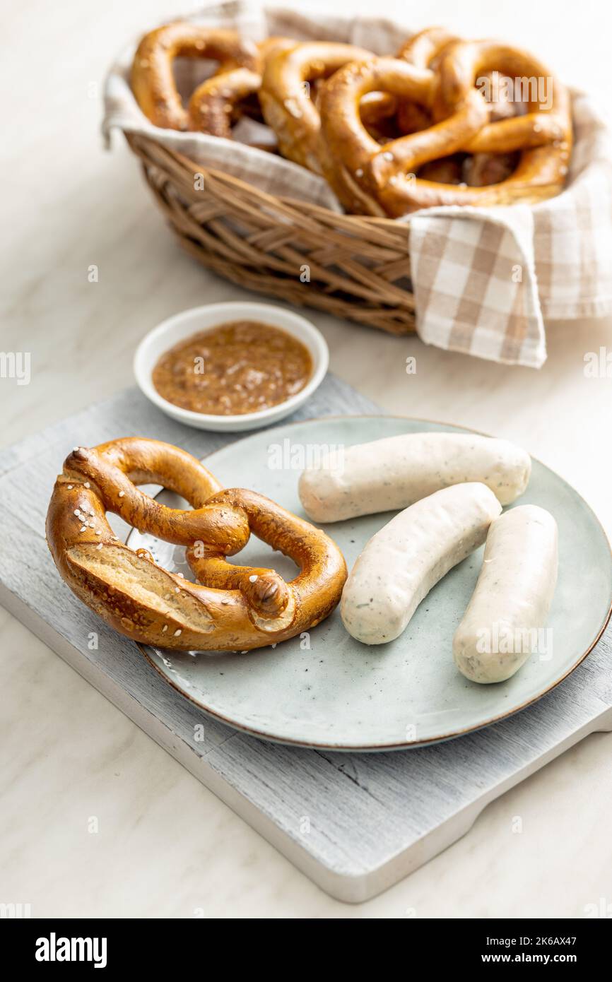 Salsicce bianche tradizionali bavaresi sul piatto e pretzes. Foto Stock