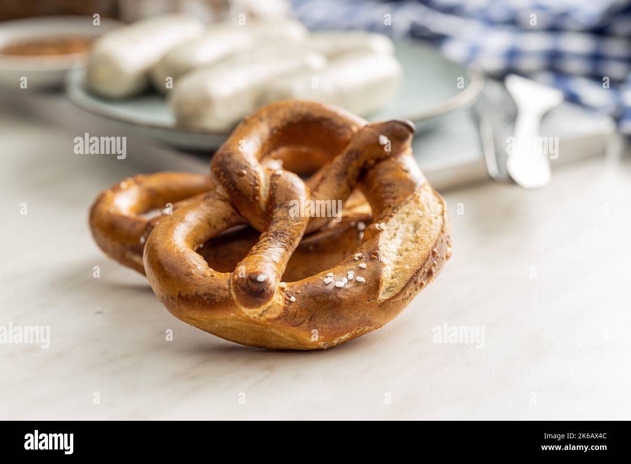 Pretzel bavaresi al forno sul tavolo bianco. Foto Stock