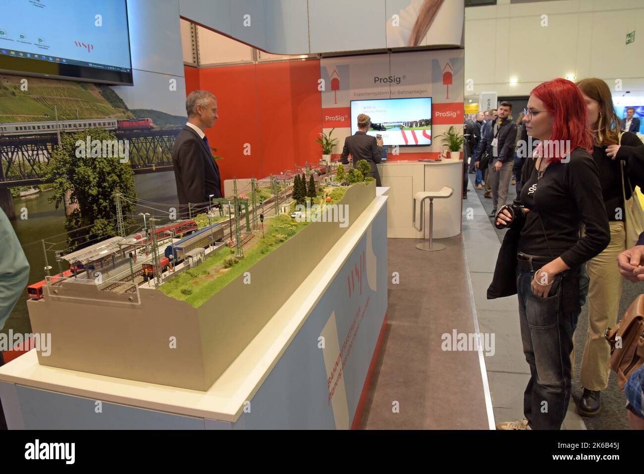 Persone che studiano una ferrovia modello in mostra all'Innotrans International Transport Expo, Berlino, settembre 2022 Foto Stock