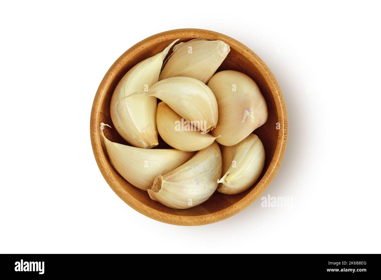 Spicchi d'aglio fresco in recipiente di legno su fondo bianco Foto Stock