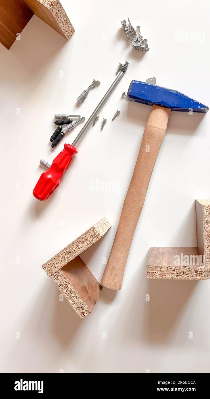Utensili meccanici impostati su bianco. Attrezzatura di fissaggio isolata su sfondo bianco. Martello blu, cacciavite rosso, legno e viti Foto Stock