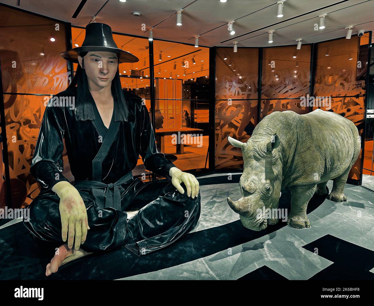Le statue di un rinoceronte e di un uomo vestito di nero, all'interno del negozio Gentle Monster di Pechino, Cina Foto Stock Le statue di un rinoceronte e di un uomo vestito di nero, all'interno del negozio Gentle Monster di Pechino, Cina Foto Stock
