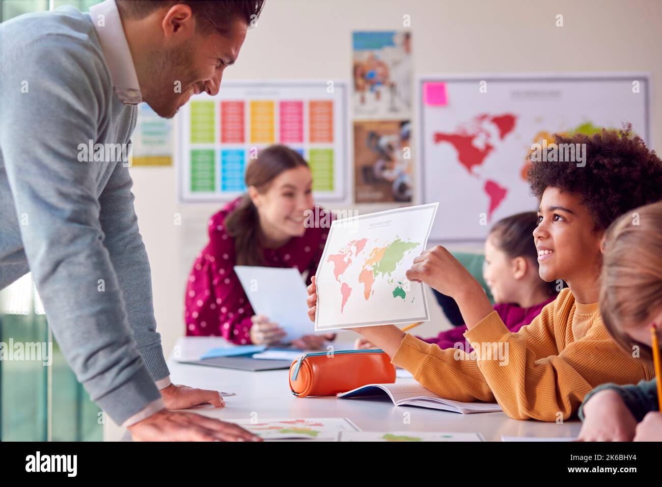 Gruppo di studenti multiculturale con insegnanti in aula che guardano la mappa nella lezione di Geografia Foto Stock