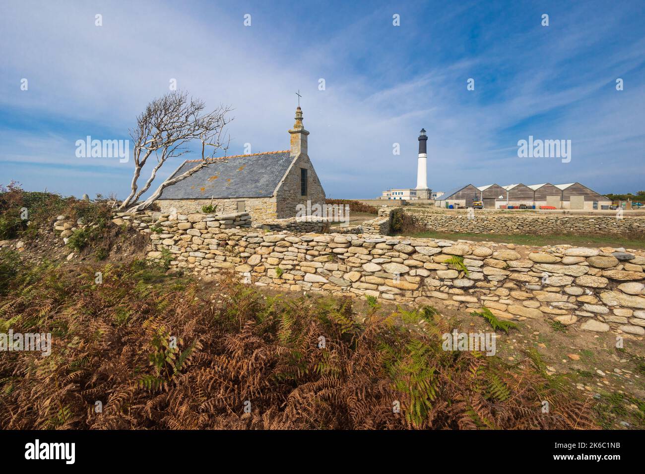 La piccola cappella e l'alto faro dell'isola di Sein, Bretagna, Francia Foto Stock