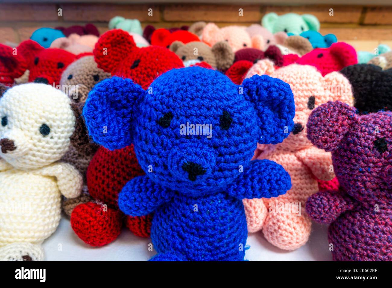 Orsacchiotti lavorati a maglia in colori colorati pronti a regalare ai bambini. Foto Stock