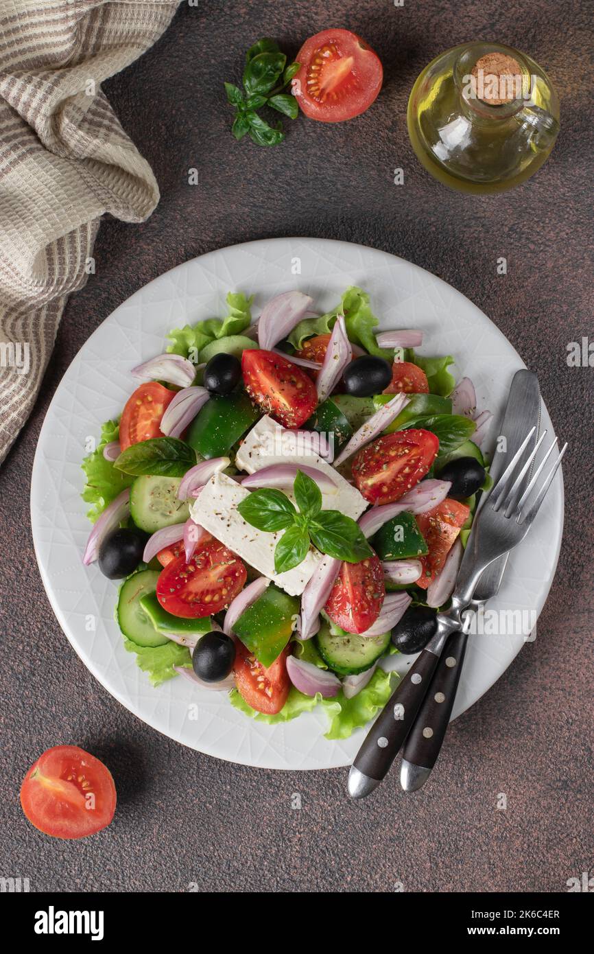 Insalata greca classica di pomodori, cetrioli, peperoni dolci, olive, basilico e feta, vista dall'alto Foto Stock