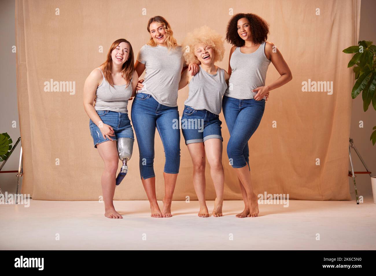 Gruppo di diverse donne vestite casualmente amici uno con arto protesico promuovere la positività del corpo Foto Stock