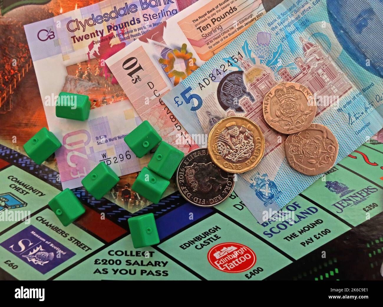 Proprietà in Scozia, banconote in contanti in sterline scozzesi sul bordo del monopolio di Edimburgo, case verdi, che rappresentano difficoltà di acquisto o locazione Foto Stock