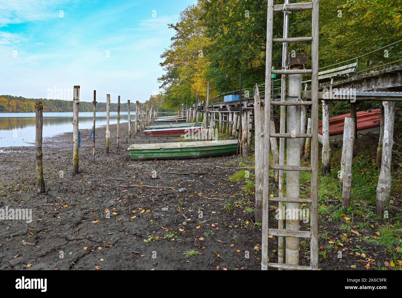 Strausberg, Germania. 13th Ott 2022. Un molo si trova a quasi due metri dalle barche, che da tempo sono state asciutte sulla punta meridionale del lago di Straussee. Per anni, il livello del lago Straussee ad est di Berlino è in costante calo. Credit: Patrick Pleul/dpa/Alamy Live News Foto Stock