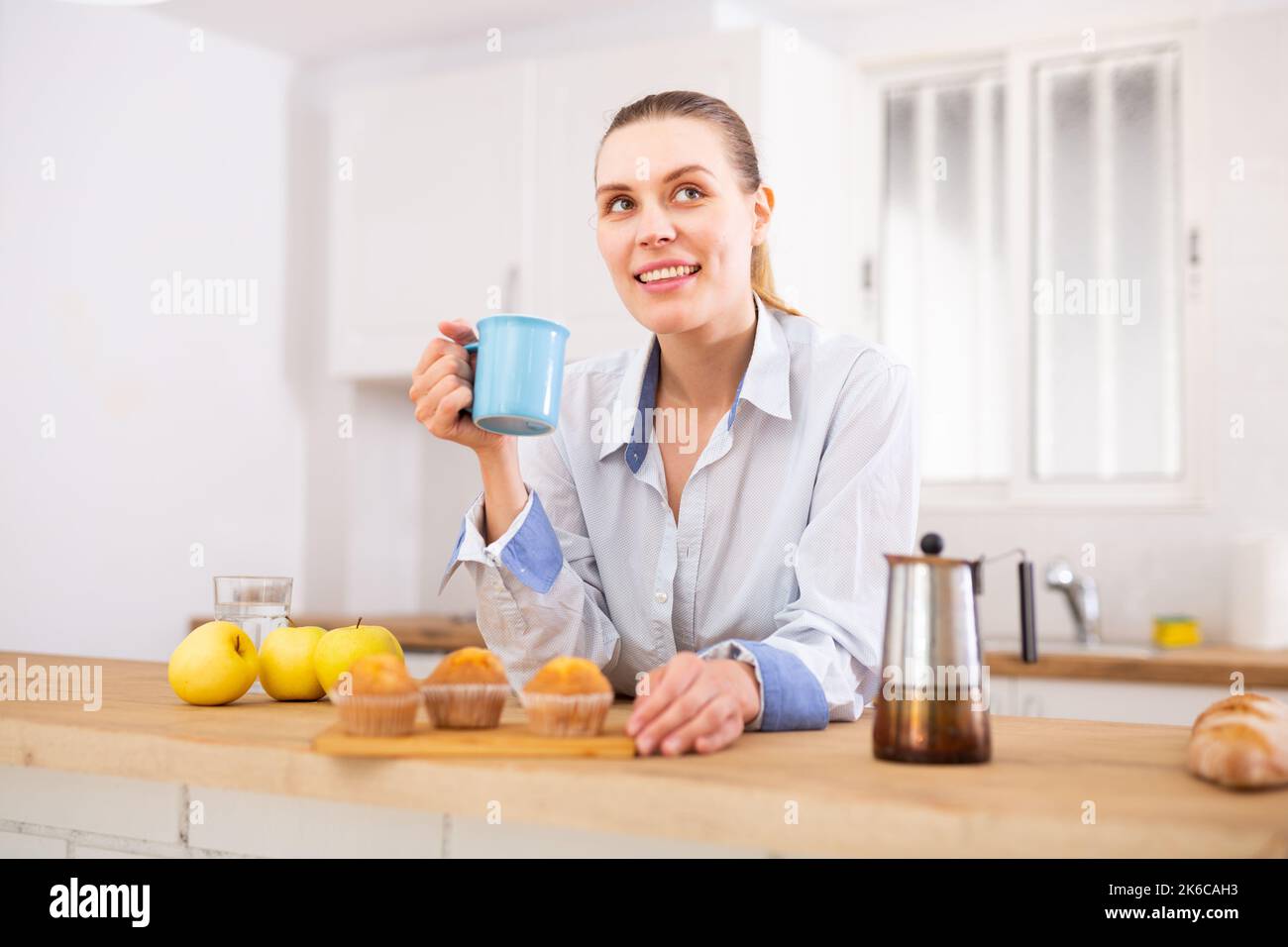 Ritratto di donna positiva bere caffè a casa Foto Stock