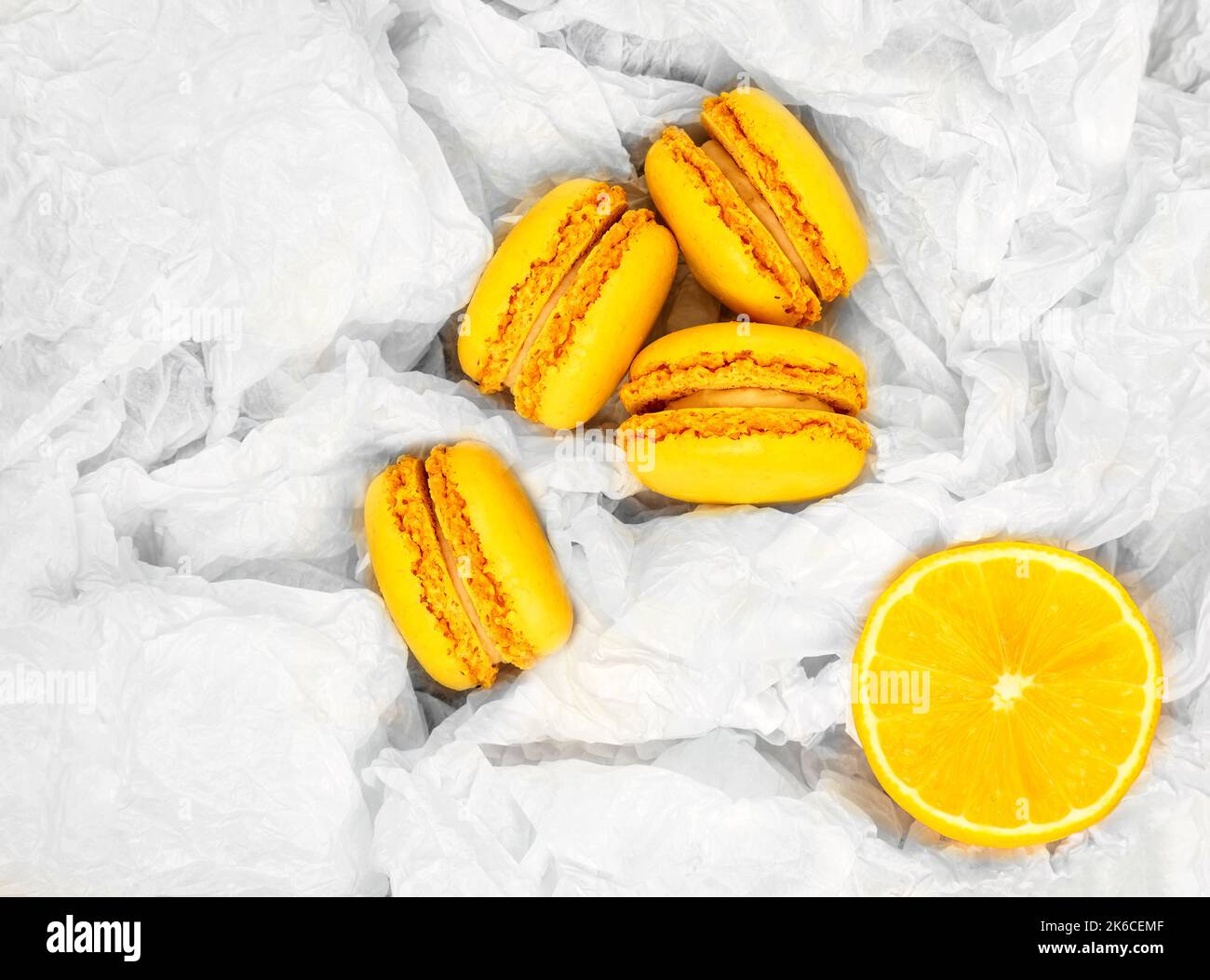 Amaretti gialli agli agrumi e una fetta di un taglio fresco limone Foto Stock