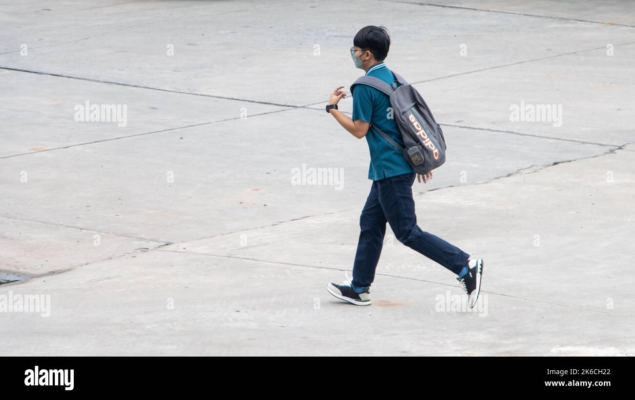 SAMUT PRAKAN, THAILANDIA, ottobre 03 2022, Un ragazzo con uno zaino corre per la strada Foto Stock