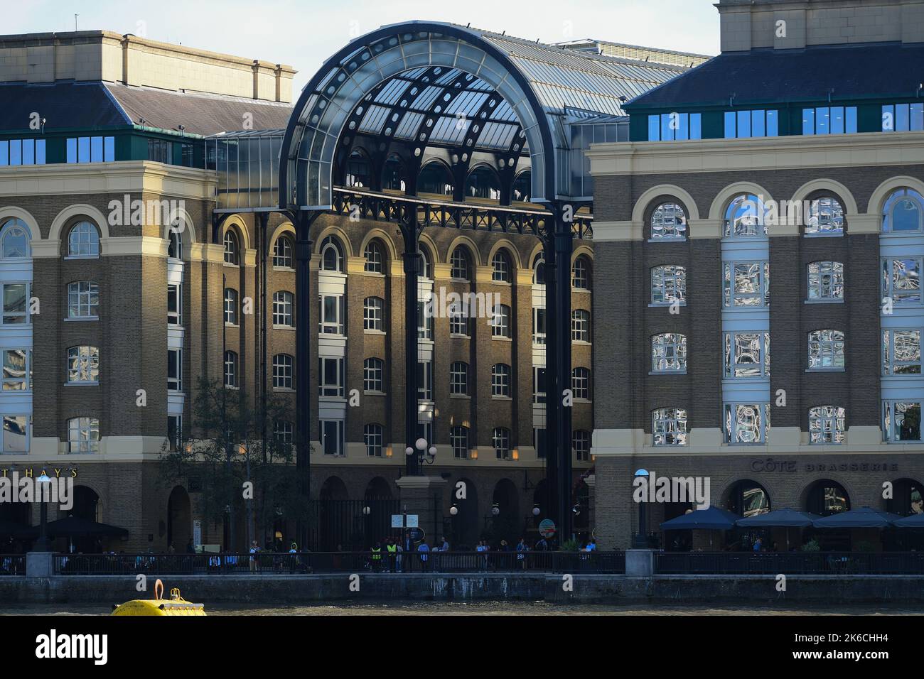 Hays Galleria visto dal molo di London Bridge come la luce del sole della sera splende attraverso il tetto ornato. Foto Stock
