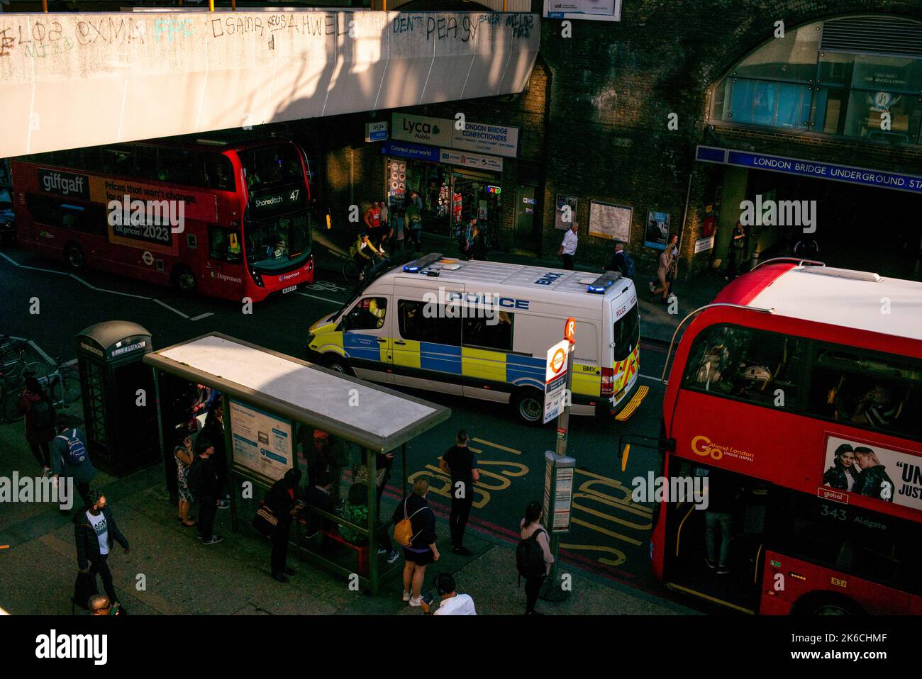 Un pulmino di polizia funziona il suo senso attraverso il traffico e gli autobus di Londra a London Bridge Underground station.viewed from above. Duke Street collina. Foto Stock