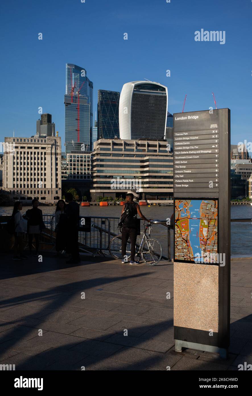 Una vista dal percorso del Tamigi vicino al London Bridge attraverso il Square Mile e il quartiere finanziario di Londra, guardando i grattacieli con la cartiera di direzione della mappa. Foto Stock