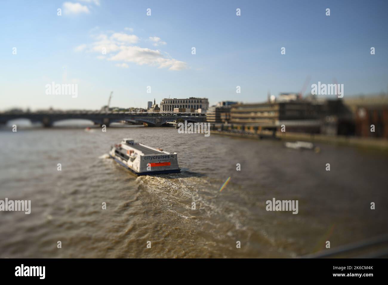 City Cruises barca che viaggia verso Blackfriars Bridge London UK scattata con effetto shift Lens alla luce della sera. Foto Stock