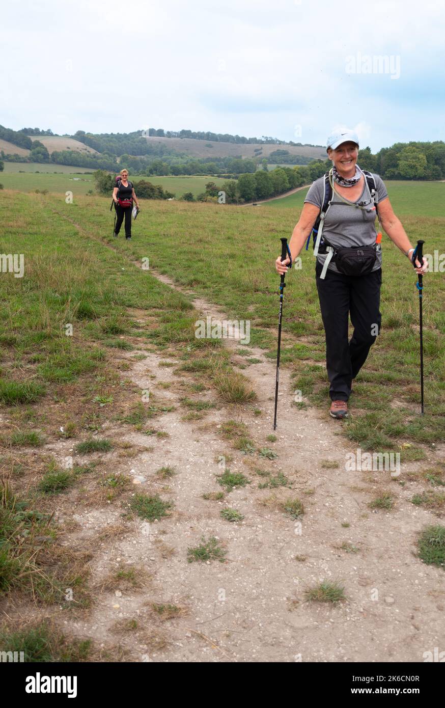 Due escursionisti femminili che camminano lungo la South Downs Way nell'Hampshire, Inghilterra Foto Stock