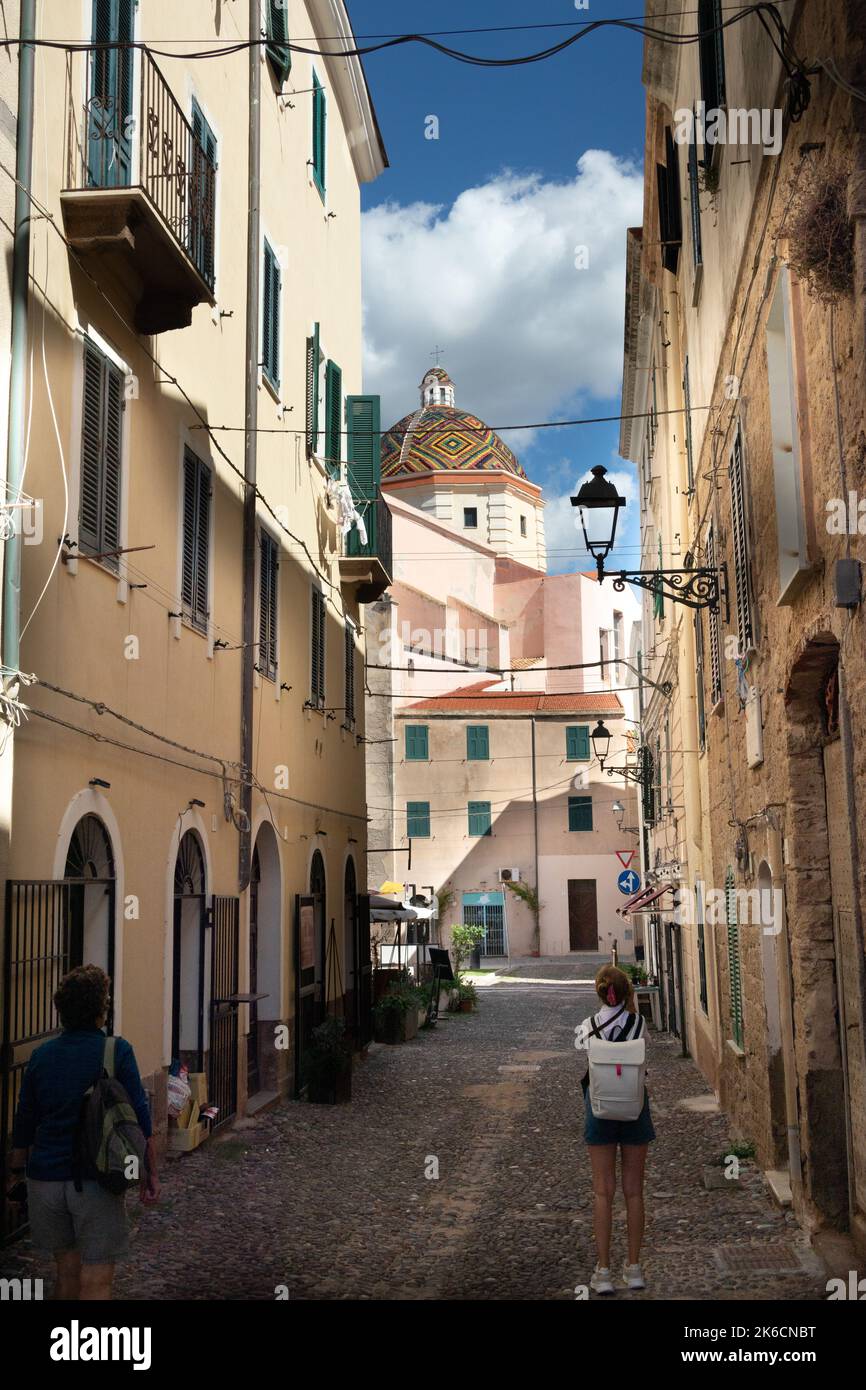 Strada vecchia con la colorata cupola piastrellata della Chiesa di San Michele, Chiesa San Michele nella città catalana di Alghero Sardegna, Italia Foto Stock