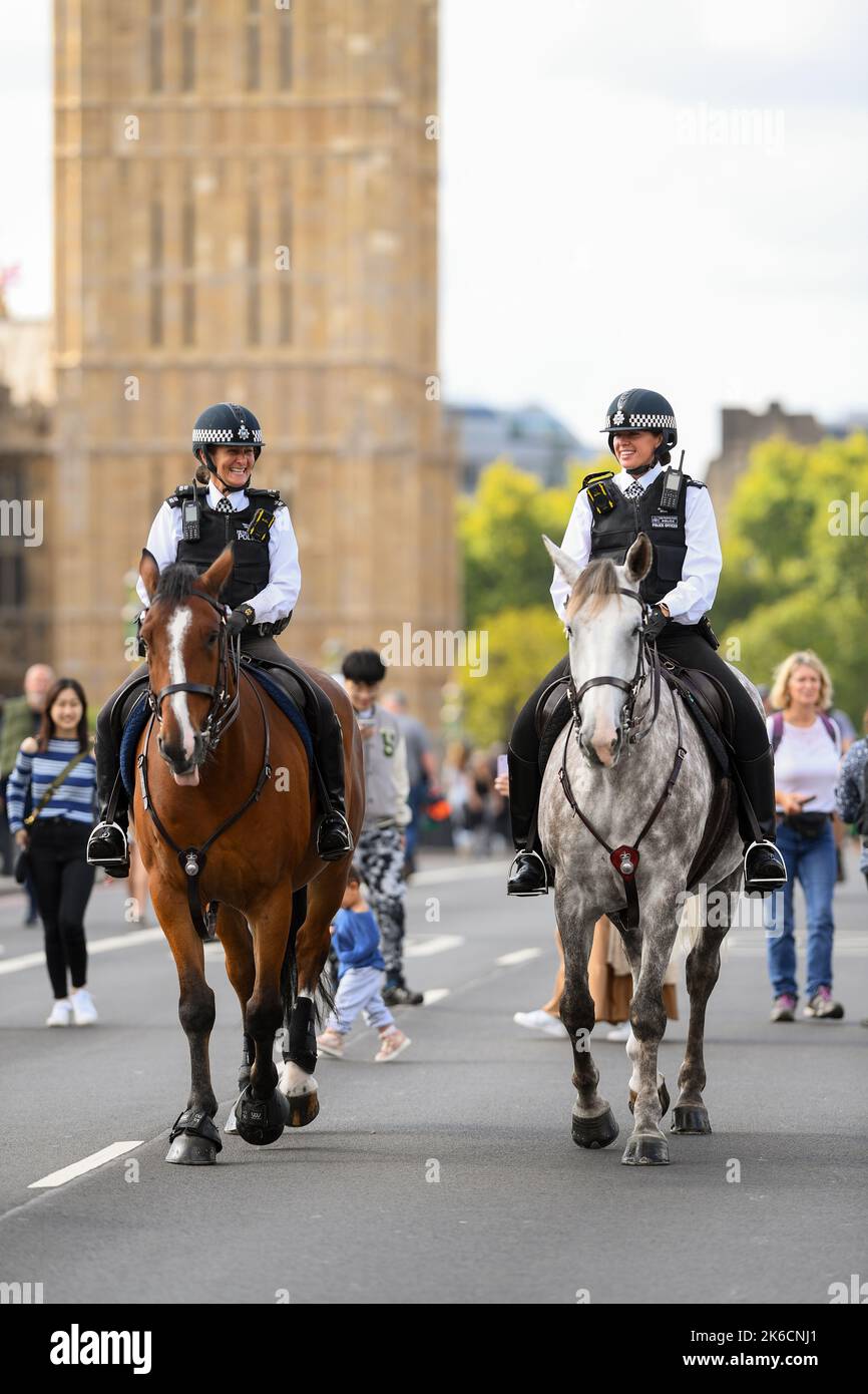 Due poliziotti montati da donne attraversano il Westminster Bridge pattugliando il primo giorno della defunto Regina Elisabetta 2nd che si trova nello stato. Londra Regno Unito Foto Stock