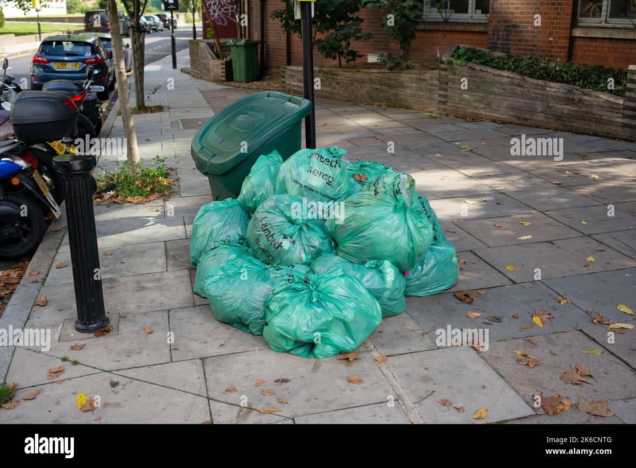 I sacchi verdi per la raccolta dei rifiuti Lambeth Council si sono accumulati per strada pronti per la raccolta a Londra UK. Foto Stock