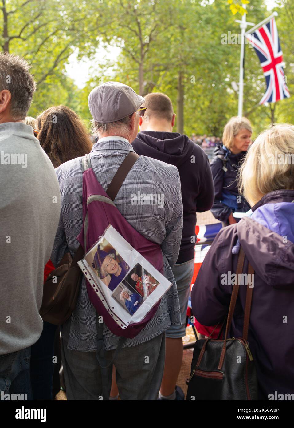 Un vecchio gentiluomo si trova al Mall London nella folla con foto della Regina in attesa del momento in cui la bara Queens passa a trovarsi nello Stato. Foto Stock