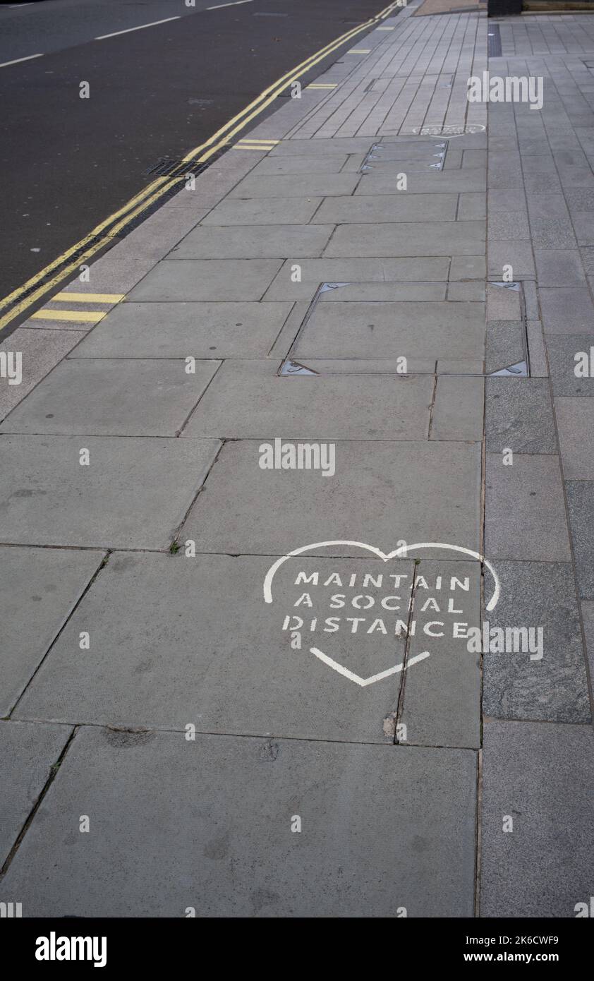 Mantenere un cartello sociale distanza marciapiede cuore sulle strade di London Palace Street UK. Foto Stock